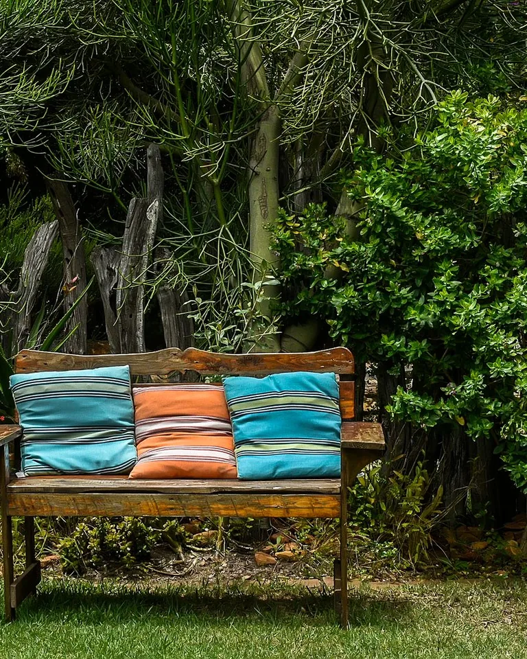Wooden bench styled with bright colorful cushions