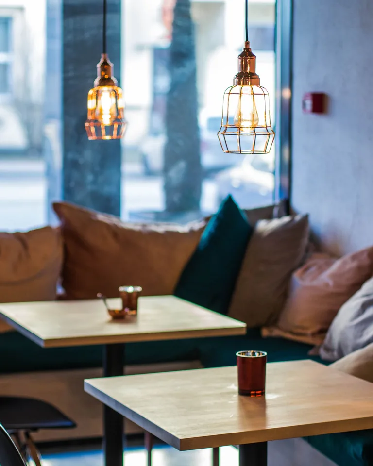 Warm cafe interior with modern pendant lighting over tables
