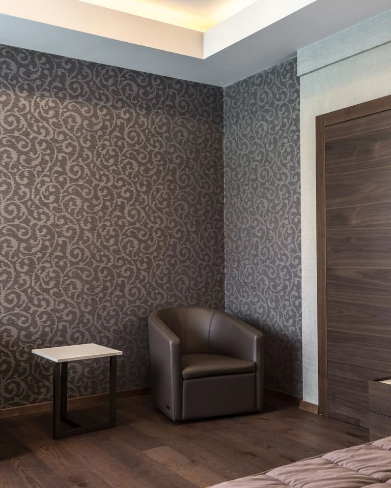 Mocha beige accent wall behind the bed in a warm bedroom
