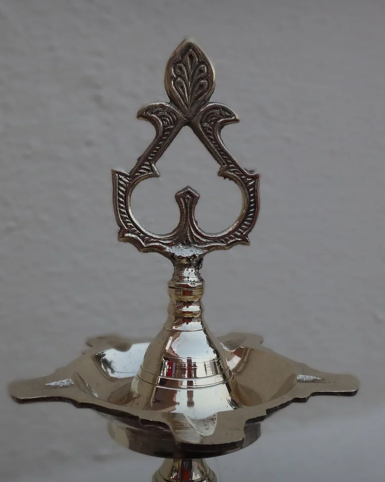 Brass table lamp on a bedroom nightstand with a warm shade