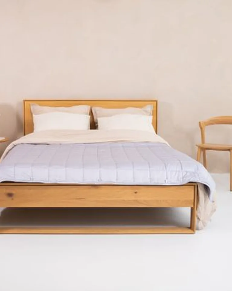 Bed tucked into the corner of a small bedroom to free up floor space