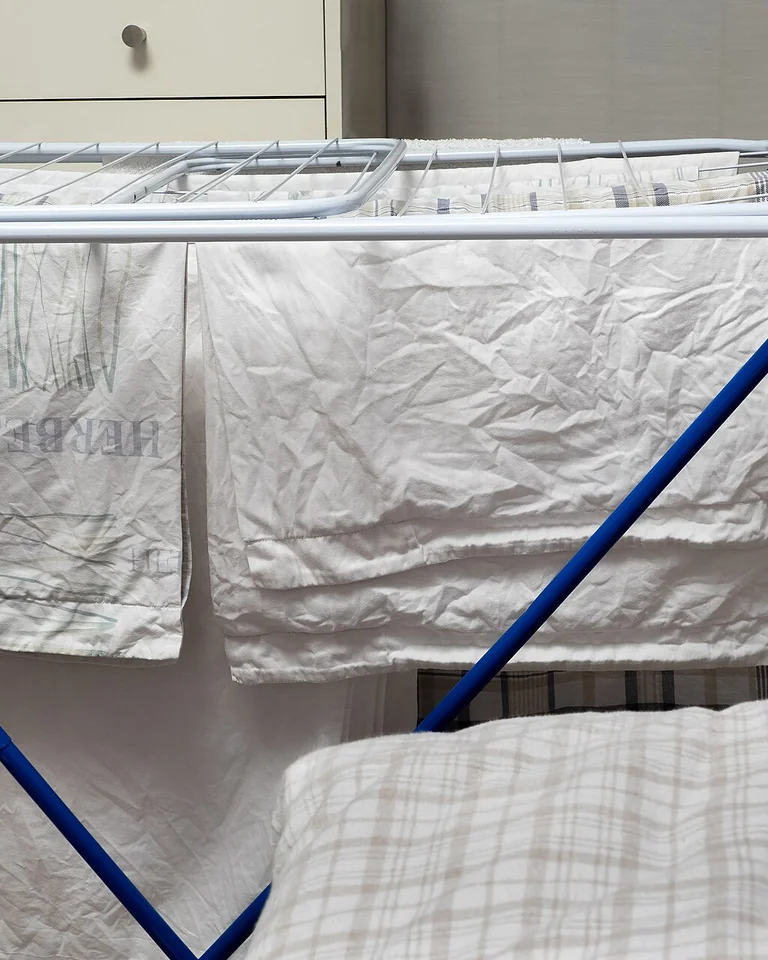 White laundry hanging to air dry on a rack
