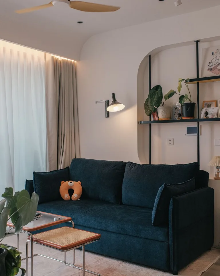 A bright airy living room with open windows and a plant