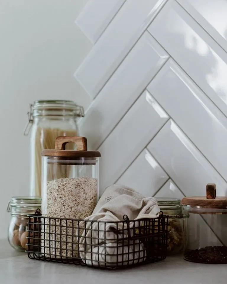 Glass canister jars filled with coffee beans and sugar on a counter