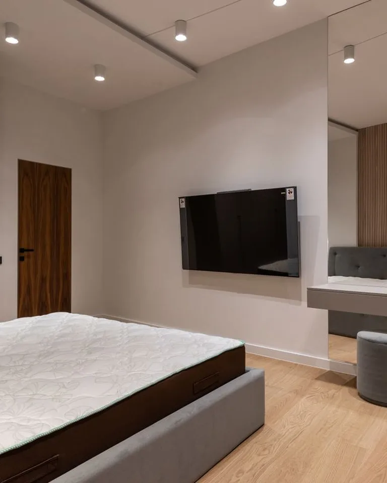 Large mirror in a small bedroom reflecting light to make the space feel bigger
