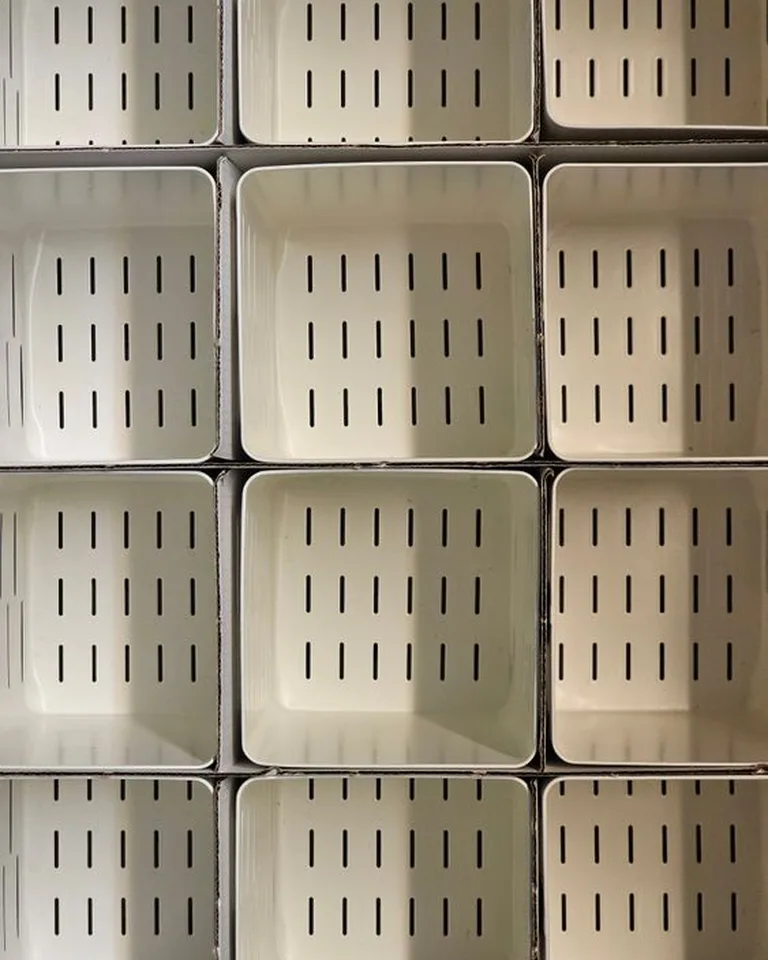 Flat rolling bins sliding under a bed for low-ceiling bedroom storage