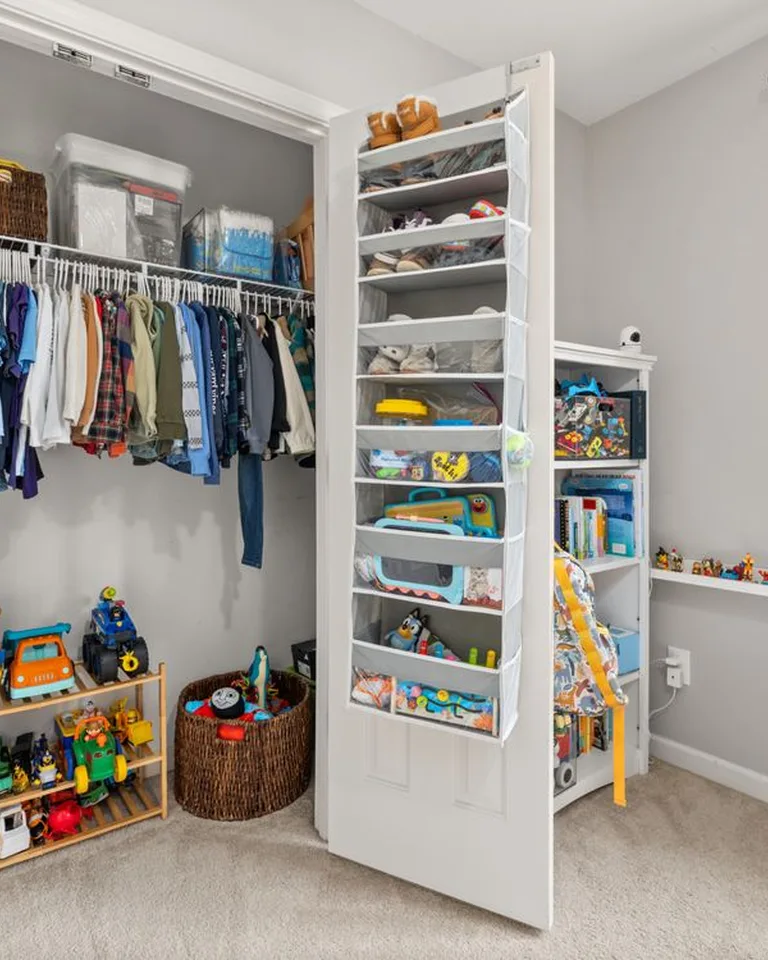 An over-the-door organizer on a bedroom closet door holding shoes and accessories