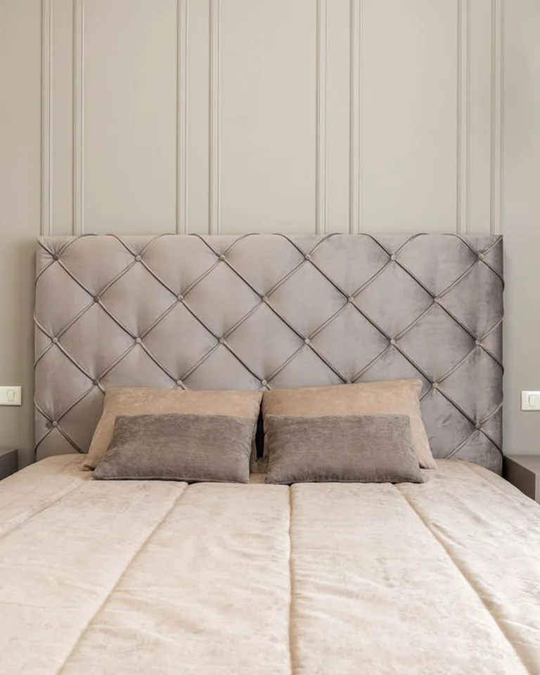 A bed with pendant lights hanging on both sides instead of table lamps