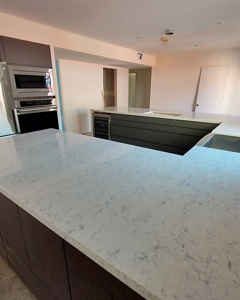 Light quartz kitchen countertop with dark base cabinets
