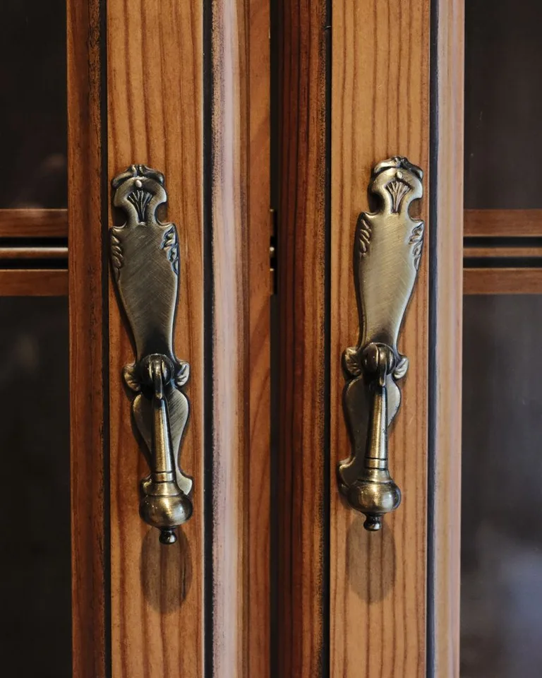 Antique-style brass cabinet pulls on wooden doors