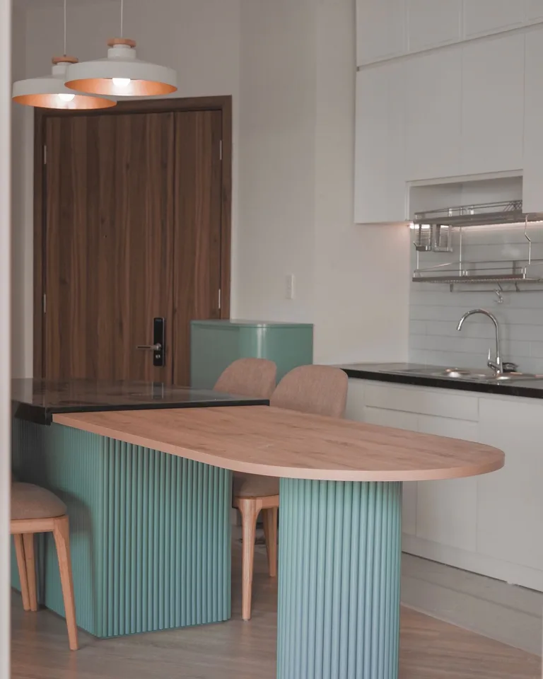 Kitchen island with mint-green fluted paneling and a wood countertop