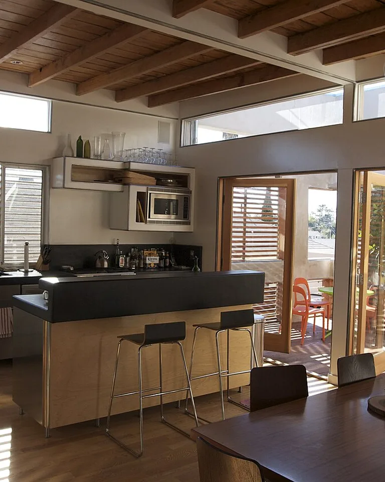 Kitchen with warm wood island paneling and exposed wood ceiling beams