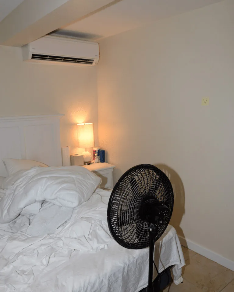 A bedroom lamp casting warm layered light that keeps olive walls rich