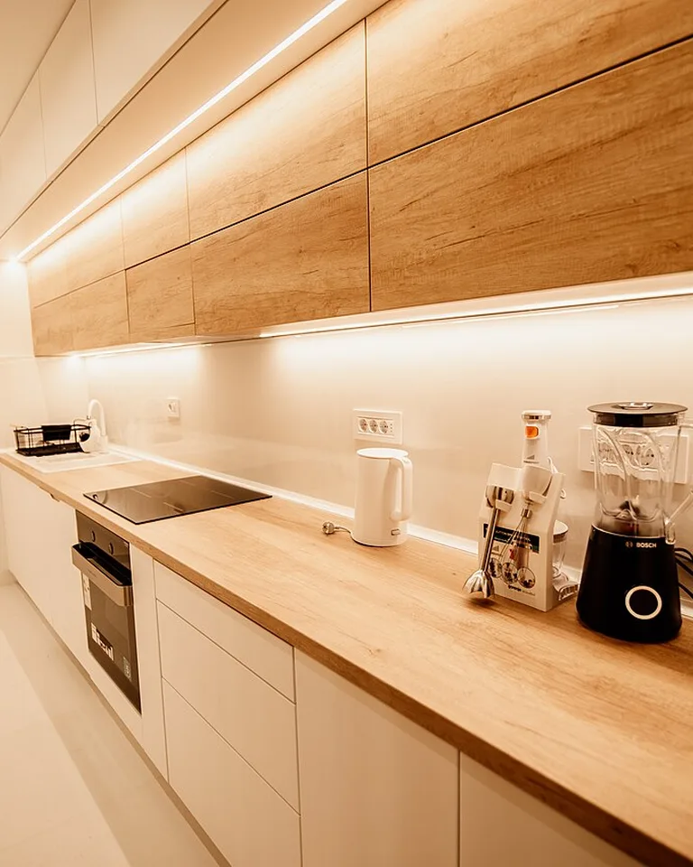 Layered lighting over a one-wall kitchen counter