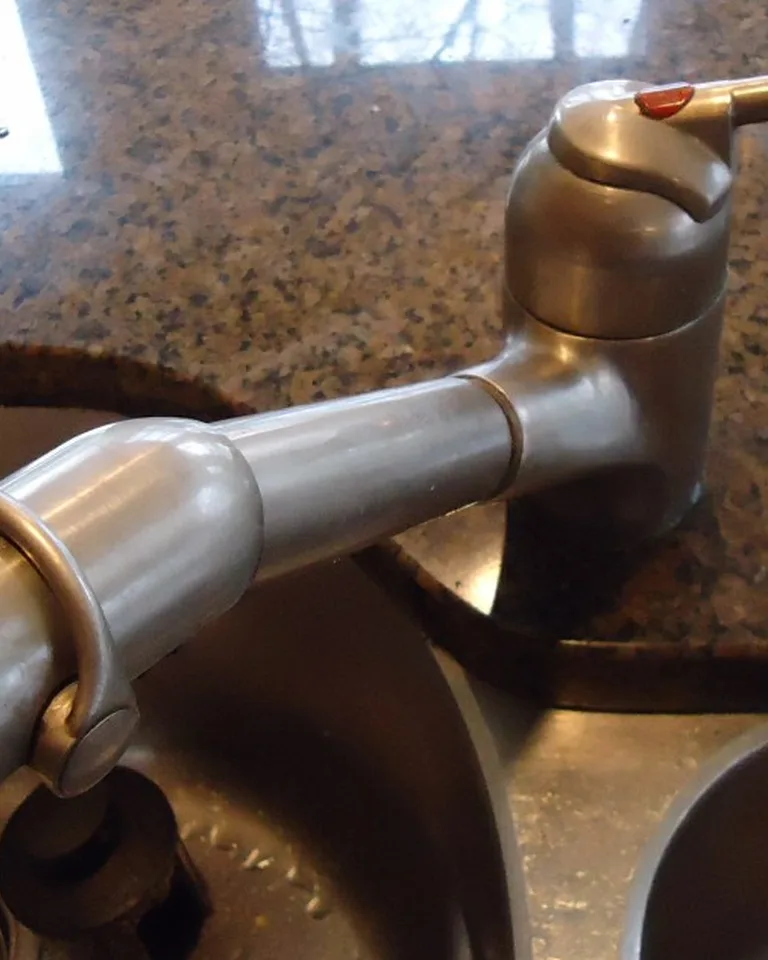 A kitchen sink with a bridge-style faucet