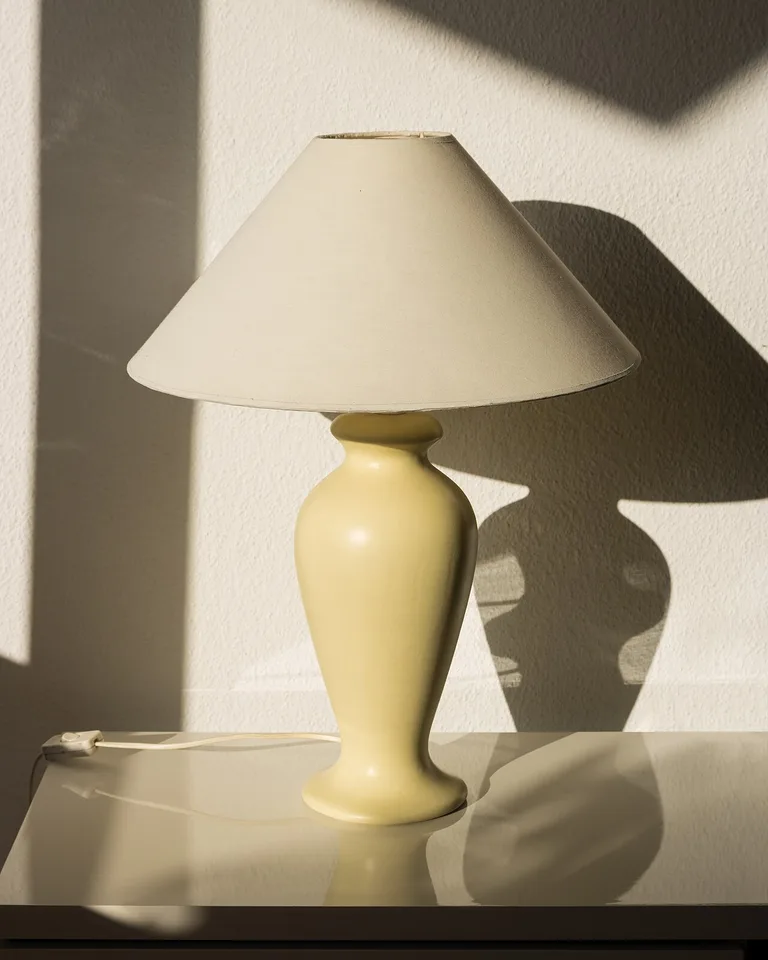Table lamp with a fabric shade glowing in sunlight