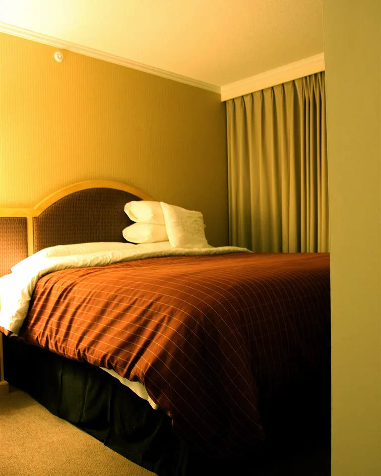 Bedroom with faux marble peel-and-stick wallpaper in soft gray veining behind a modern bed
