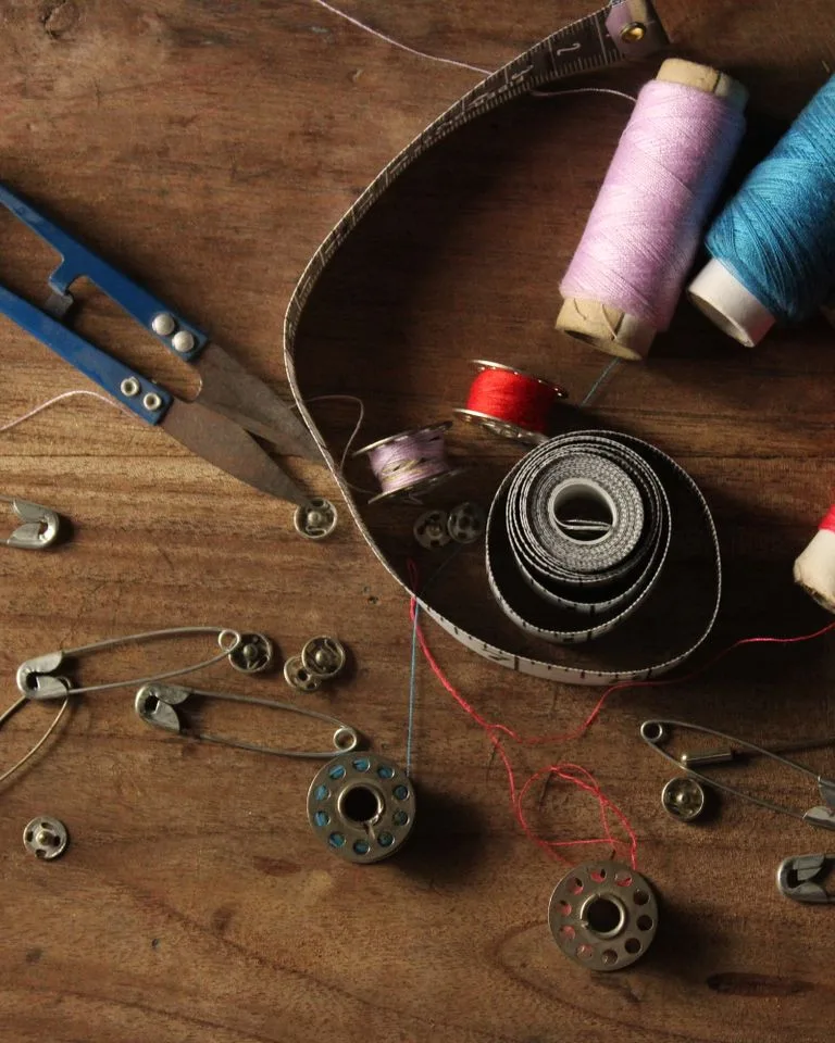 Colorful sewing supplies arranged on a wooden table