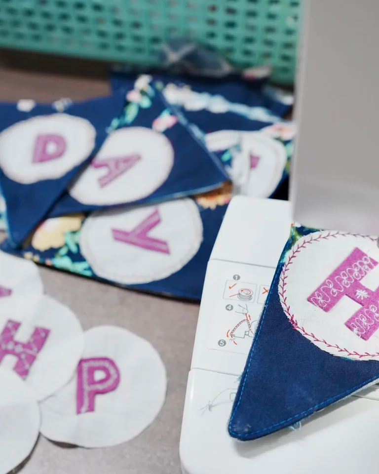 Sewing machine set up with colorful supplies for a craft project