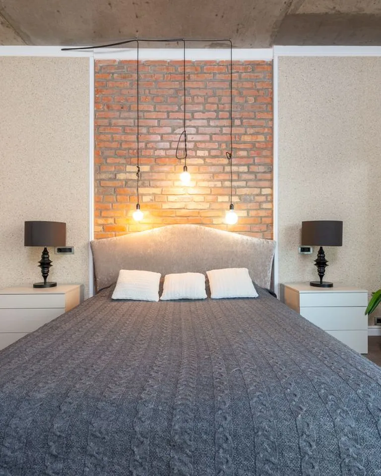 Swing-arm wall sconce beside a bed for reading light
