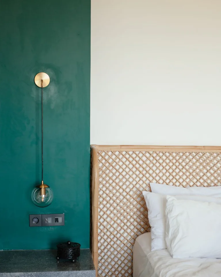 Single statement wall sconce mounted off-center in a bedroom