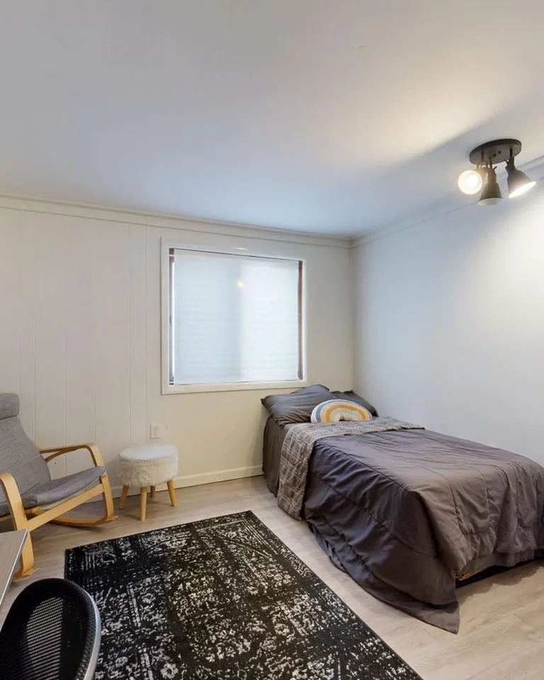 Small gray bedroom with raised furniture showing open floor underneath