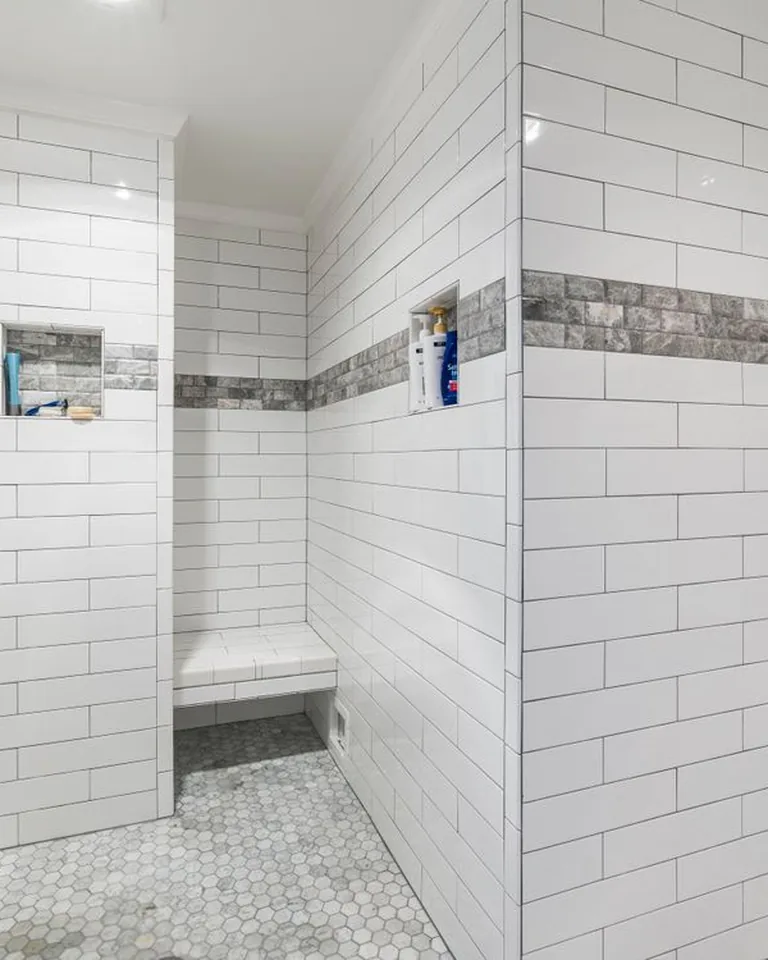 Modern high-pressure handheld showerhead with hose in a rental bathroom shower