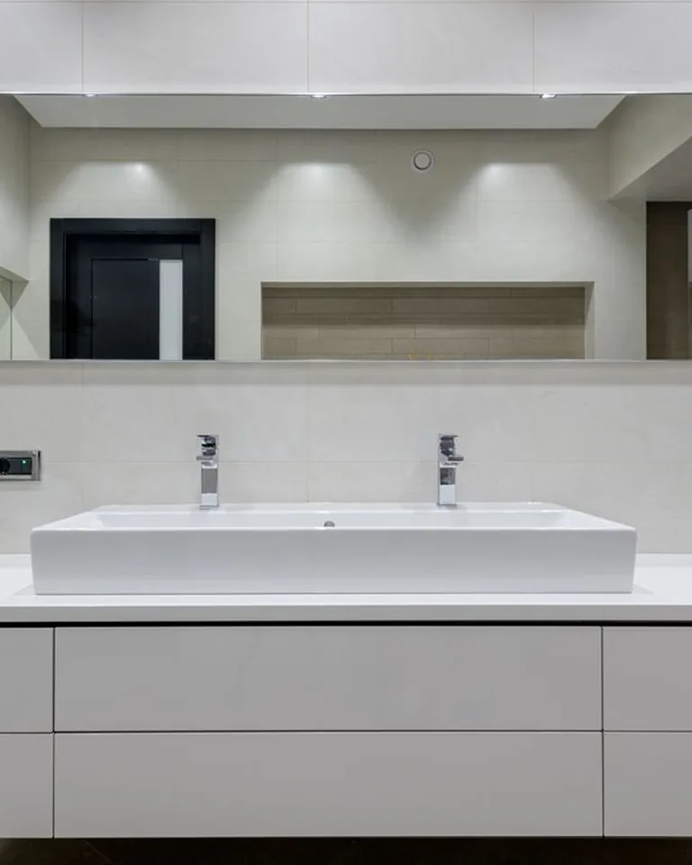 Rental bathroom vanity countertop covered in white marble-look waterproof contact paper with styled accessories