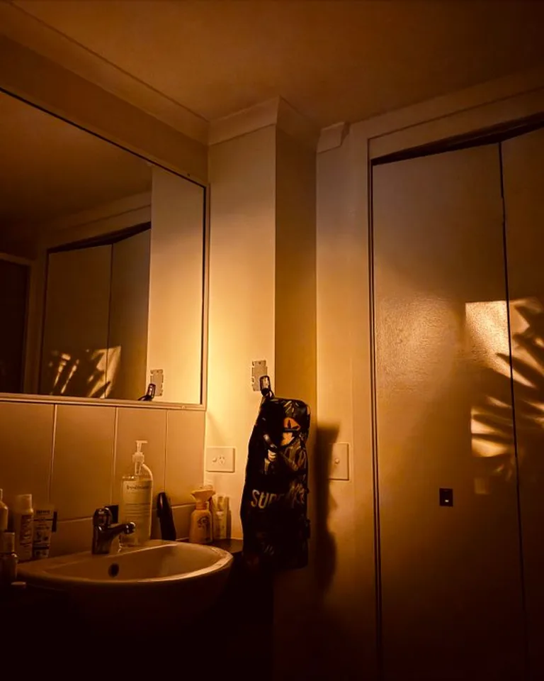 Rental bathroom at night glowing with warm LED strip light under the vanity and a soft motion-sensor nightlight