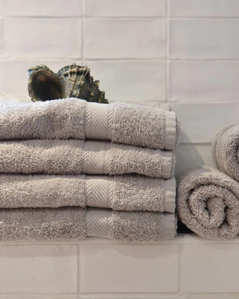Neatly stacked and rolled towels on bathroom shelving