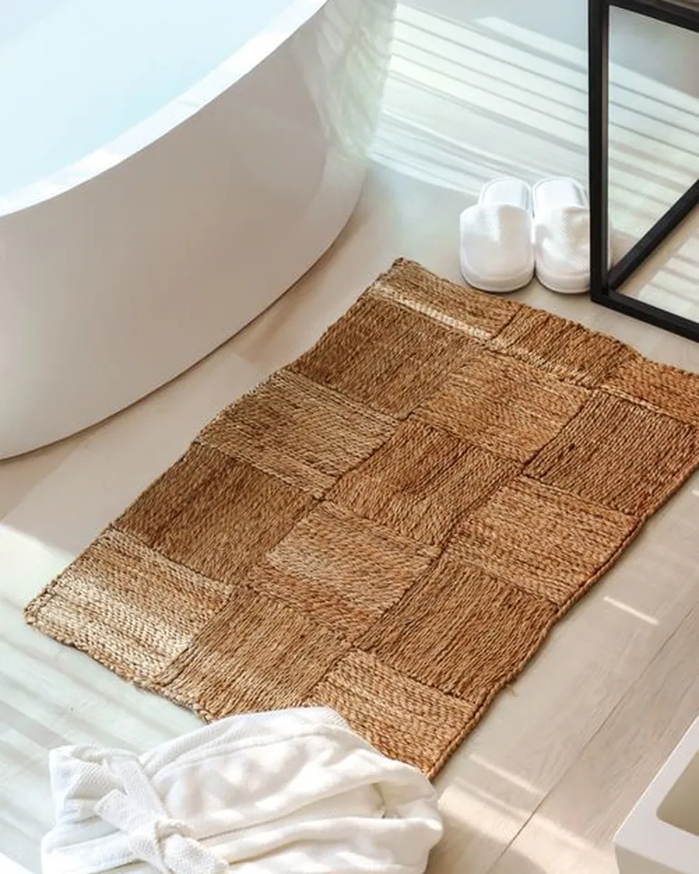 Rental bathroom with a patterned washable rug covering dated tile flooring in front of the vanity