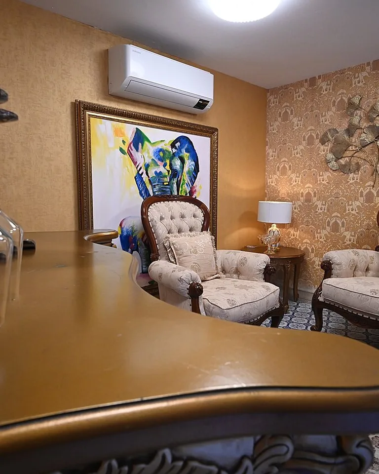 Eclectic sitting area with warm gold walls and bold colorful artwork