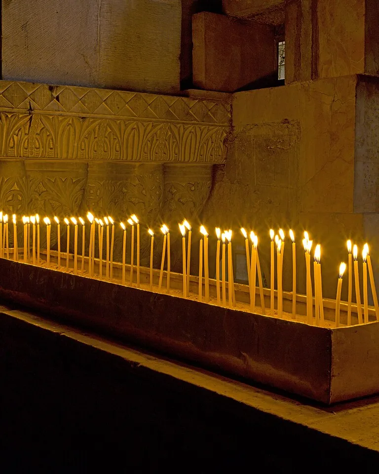 Rows of lit candles glowing warmly