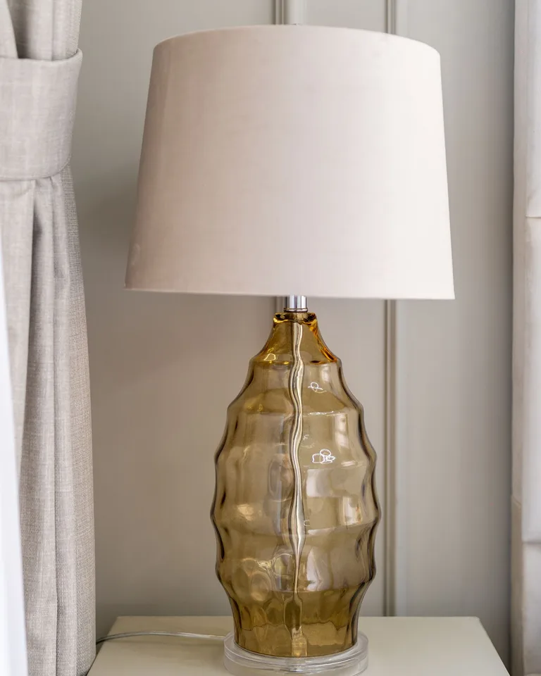 Amber glass table lamp with a neutral fabric shade