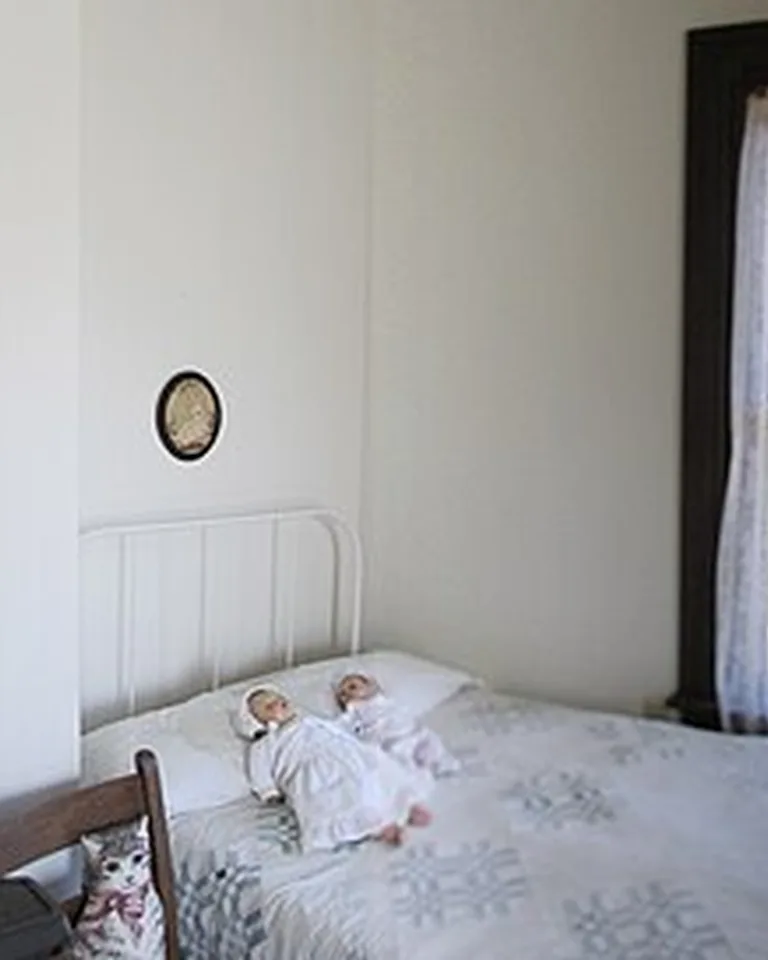 Vintage child's bedroom with dolls on the bed