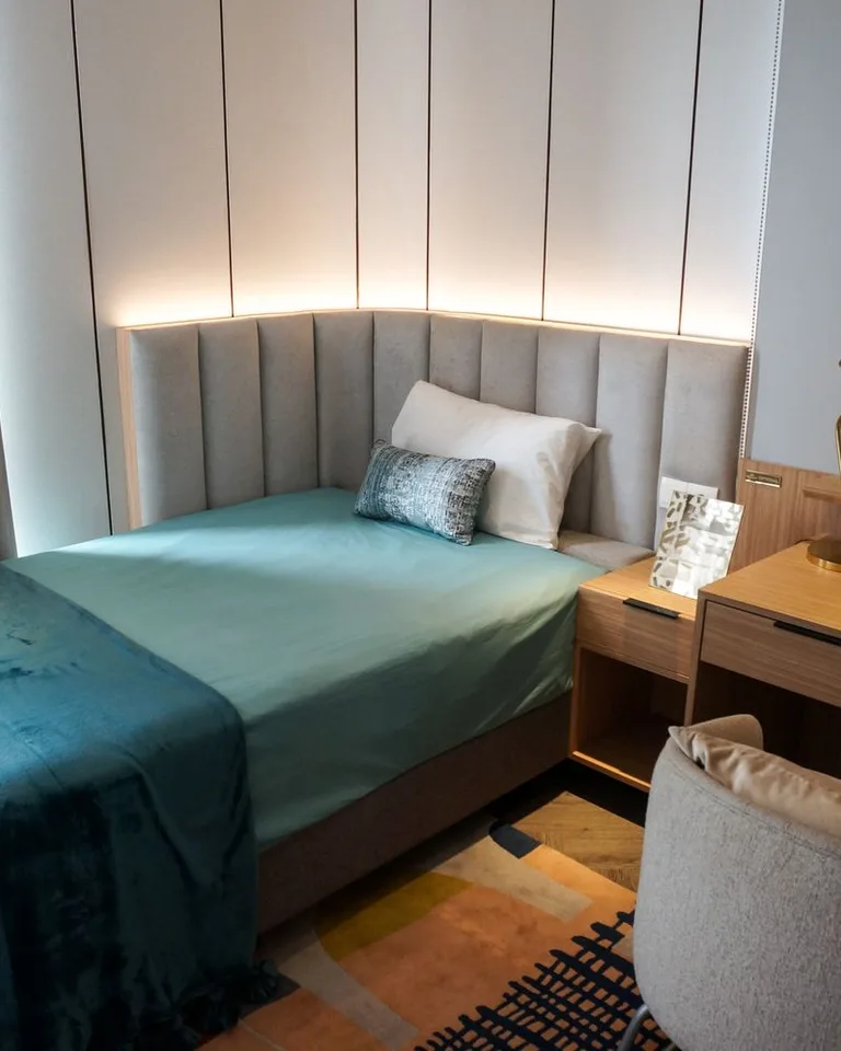 Small apartment bedroom with a neatly styled bed and side table