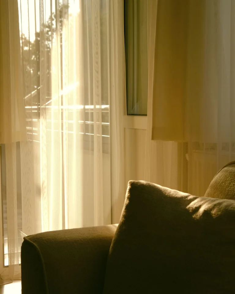 Floor-length curtains hung high above a living room window