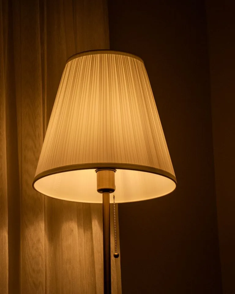 Warm table lamp glowing in a cozy apartment corner