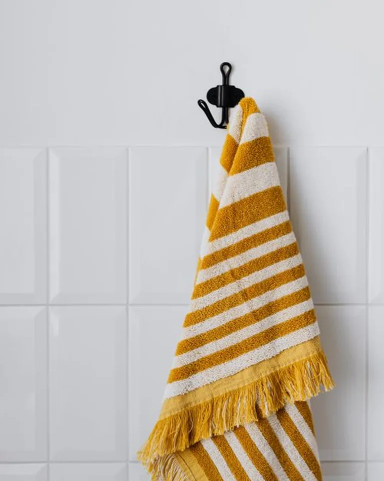 Towels hanging neatly from wall-mounted hooks in a bathroom