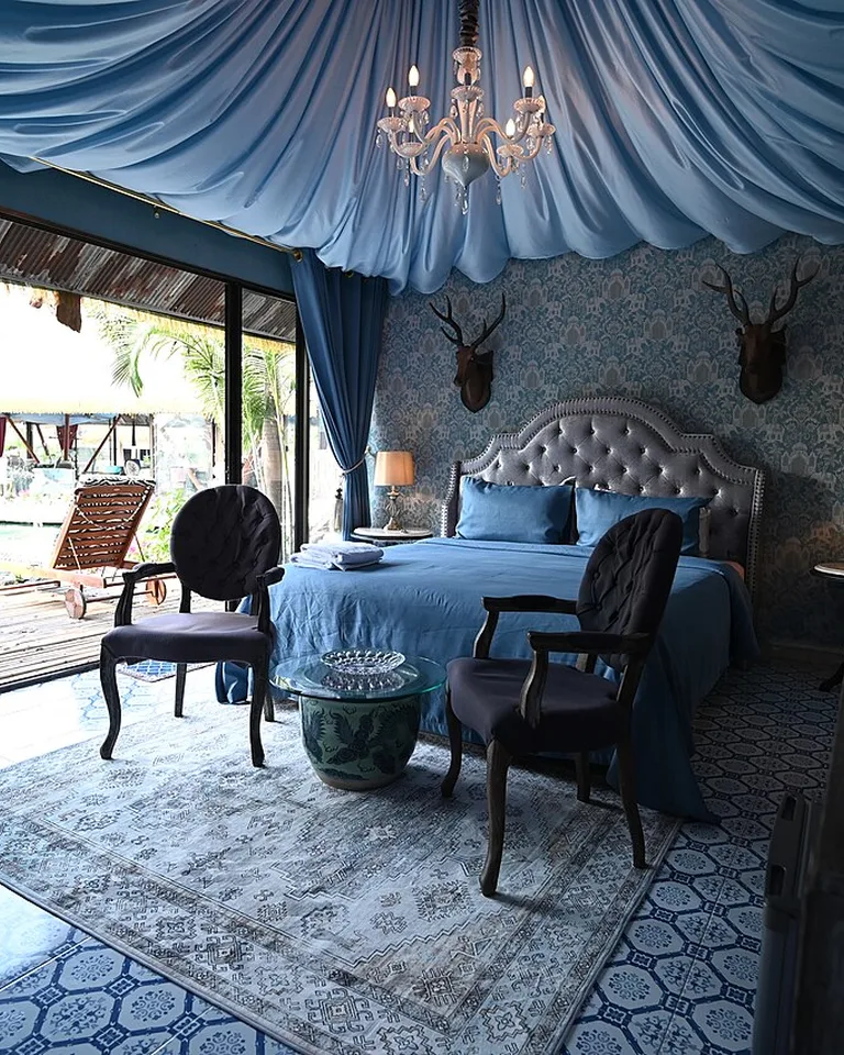 Bedroom with a tufted headboard and draped ceiling fabric