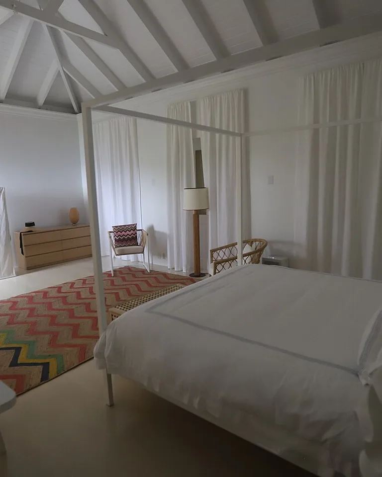 Bright white bedroom with tall curtains and a four-poster bed