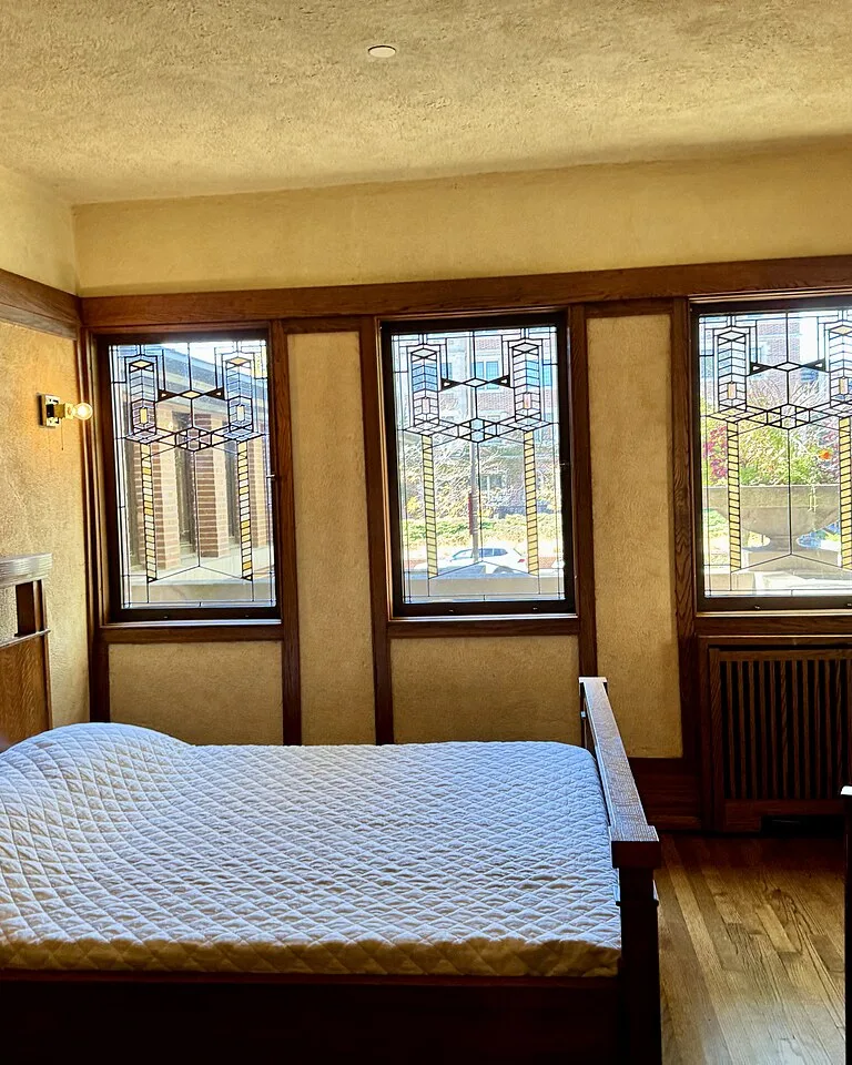 Wall sconce mounted beside a bed in a bedroom