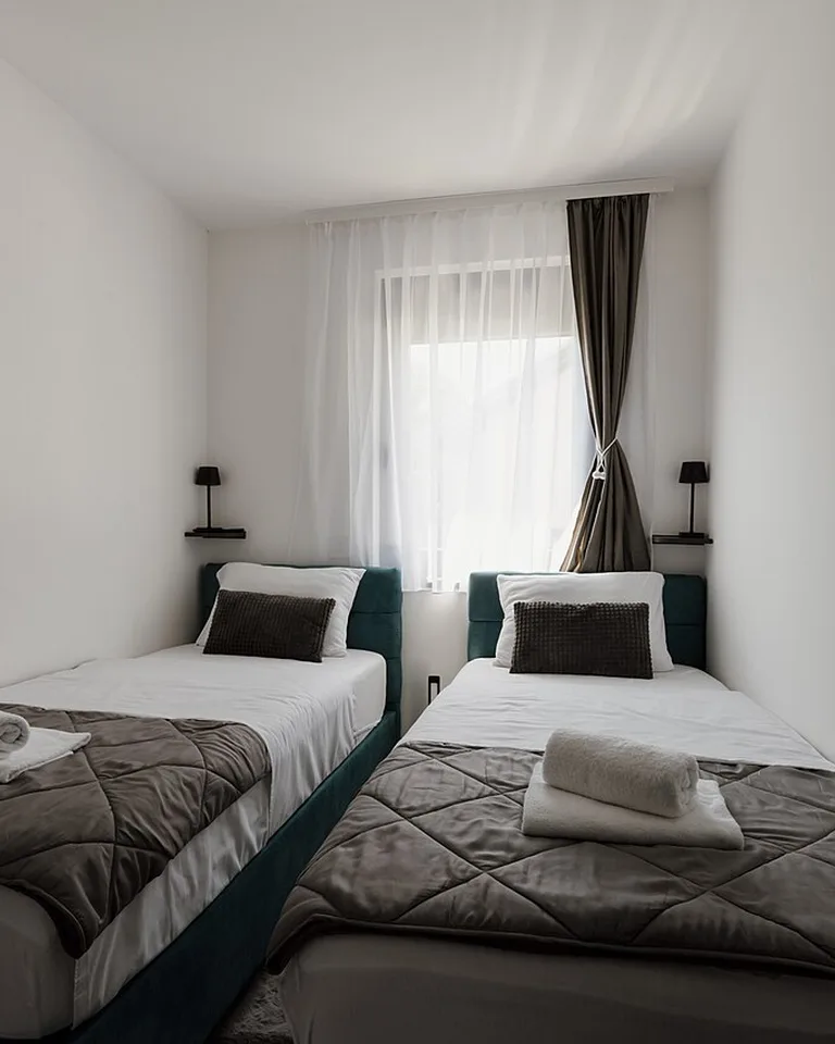 Sheer white curtains matched to white bedroom walls