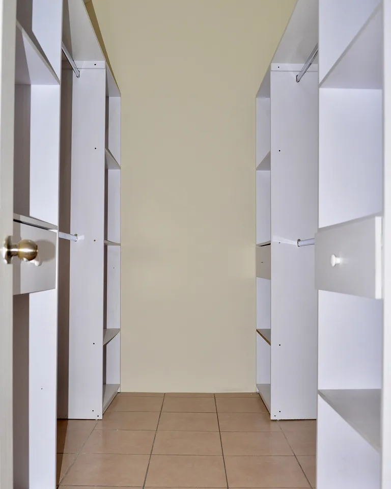White closet interior with shelves and hanging rods
