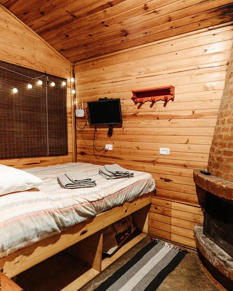 Wooden bed frame with built-in storage drawers in a small bedroom
