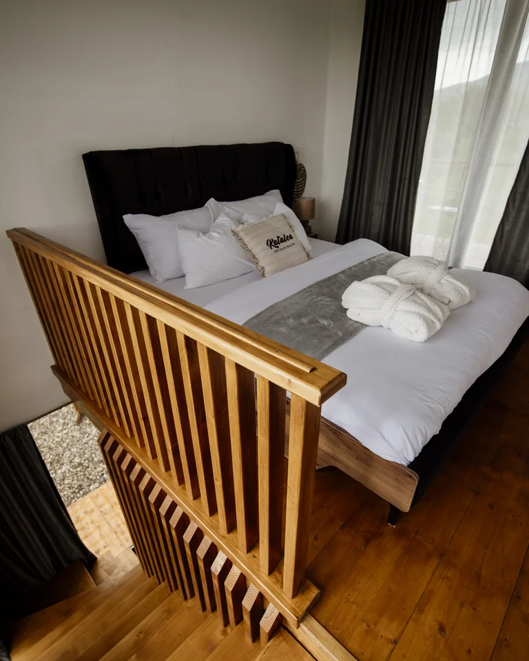 A cozy bed layered with fluffy pillows and a soft throw blanket