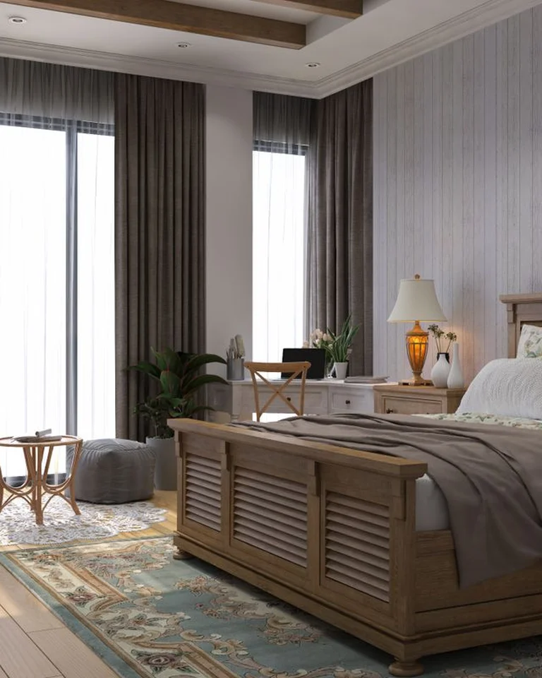 A bedroom and sitting area with separate rugs under the bed and the lounge chair