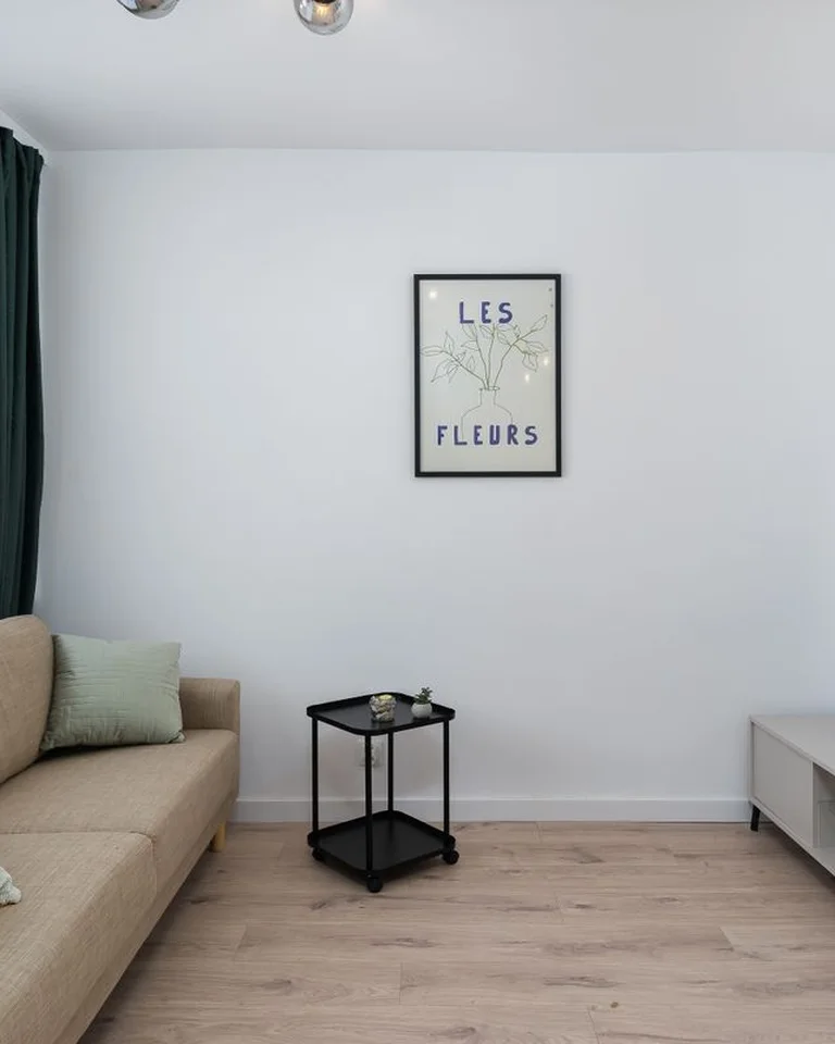 A living area with a sofa and framed art prints arranged as its own zone