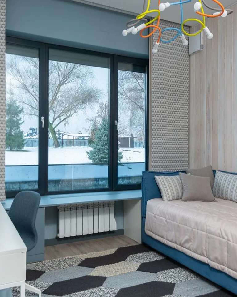 A daybed styled with layered pillows and a throw so it works as a sofa during the day