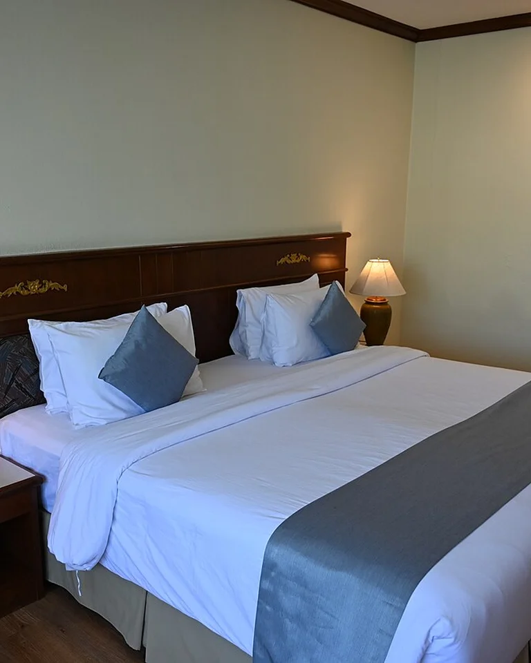 A bedroom lit by two warm bedside lamps on either side of the bed